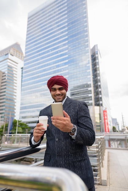 Retrato de um jovem empresário sikh indiano usando turbante enquanto explora a cidade de Bangkok, Tailândia