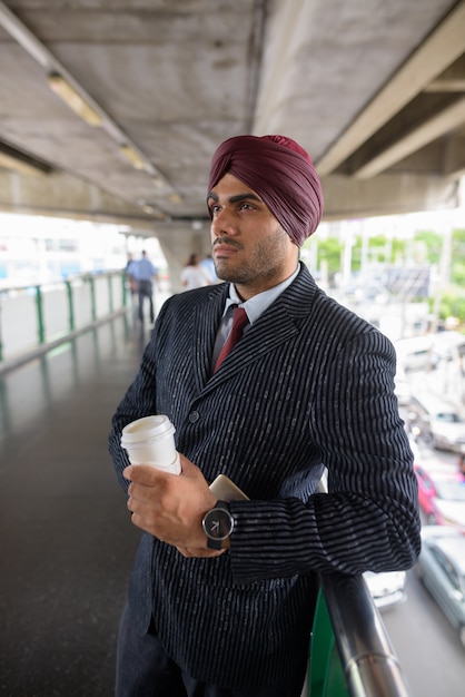 Retrato de um jovem empresário sikh indiano usando turbante enquanto explora a cidade de Bangkok, Tailândia