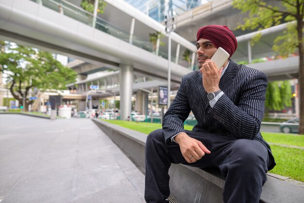Retrato de um jovem empresário sikh indiano usando turbante enquanto explora a cidade de Bangkok, Tailândia