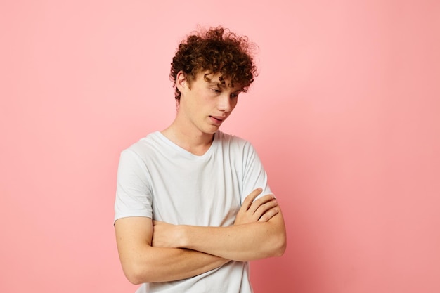 Retrato de um jovem encaracolado posando de camiseta branca estilo jovem fundo isolado inalterado