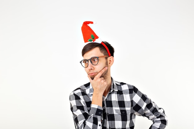 Retrato de um jovem engraçado com chapéu de Papai Noel e barba em fundo branco. Natal.