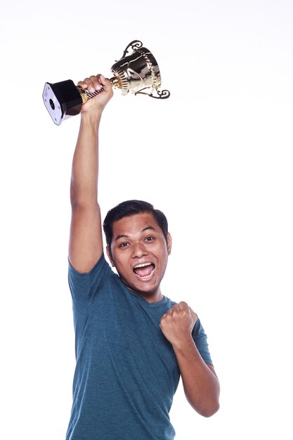 Foto retrato de um jovem entusiasmado segurando um troféu contra um fundo branco