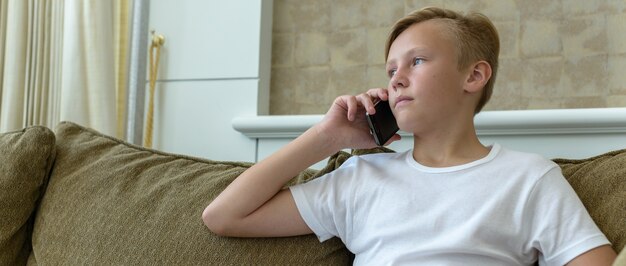 Retrato de um jovem escandinavo bonito com cabelos loiros na sala de estar em casa