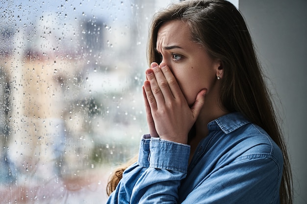 Foto retrato de um jovem estressado triste melancolia solitária mulher chocada, cobrindo a boca com as mãos durante sofrimento, choque emocional e problemas de vida