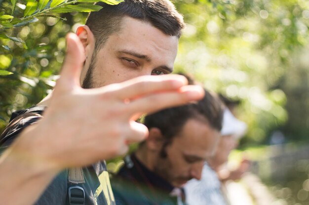 Foto retrato de um jovem fazendo gestos na floresta