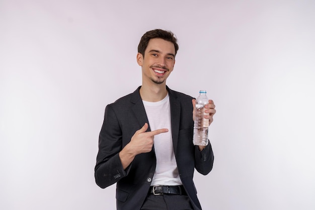 Retrato de um jovem feliz mostrando água em uma garrafa isolada sobre fundo branco