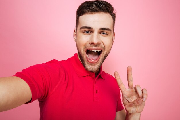 Retrato de um jovem feliz, mostrando o gesto de paz