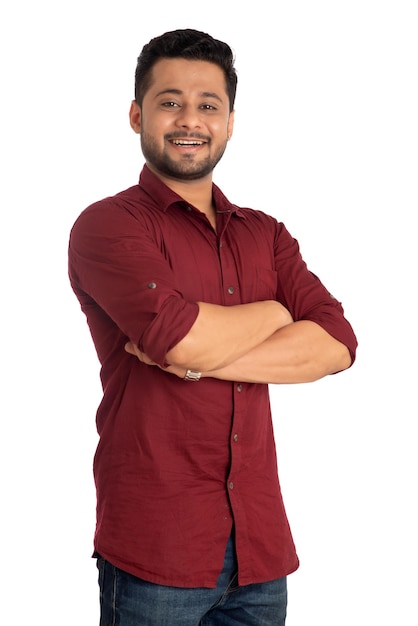 Retrato de um jovem feliz posando com os braços cruzados ou as mãos dobradas em um fundo branco