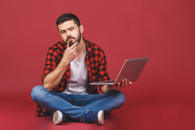 Foto retrato de um jovem feliz usando laptop