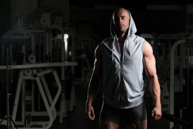 Retrato de um jovem fisicamente apto mostrando seu corpo bem treinado musculoso fisiculturista fitness modelo posando após exercícios