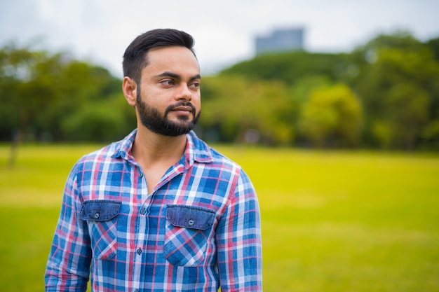 Foto retrato de um jovem indiano bonito e barbudo no parque lumpini