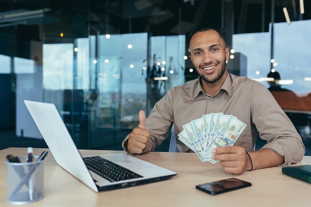 Retrato de um jovem investidor financeiro bem-sucedido sorrindo e olhando para a câmera trabalhando dentro