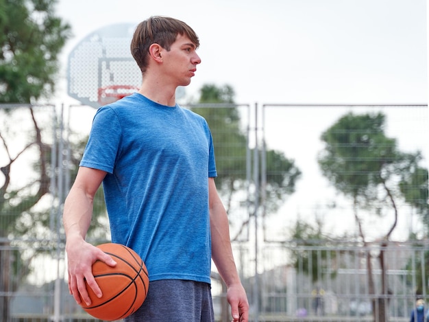 Retrato de um jovem jogador de basquete na quadra