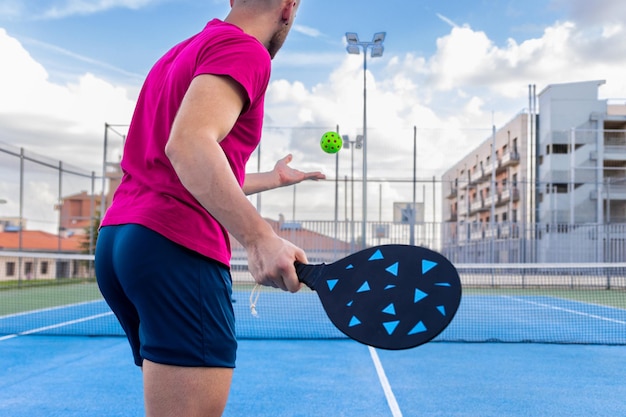 Foto retrato de um jovem jogando pickleball jovem vai realizar o ponto de saque em pickleball