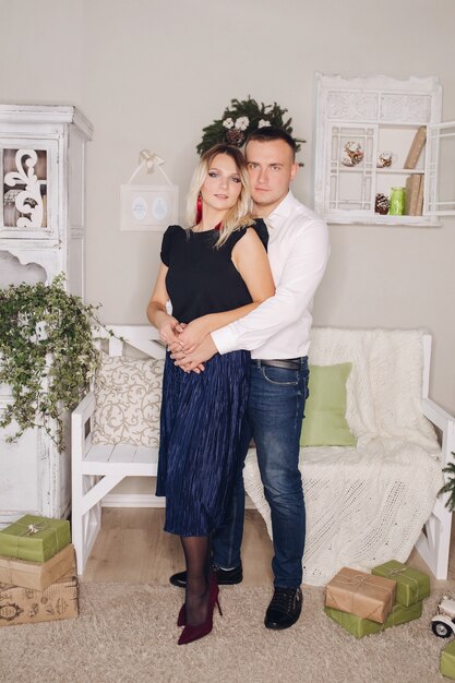 Retrato de um jovem lindo casal apaixonado por lindos trajes posando para uma sessão de fotos de ano novo em casa