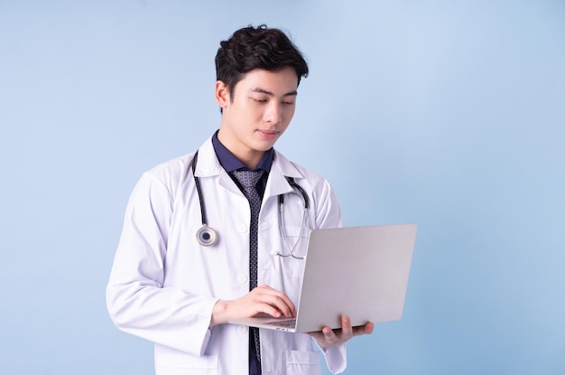Retrato de um jovem médico asiático sobre fundo azul
