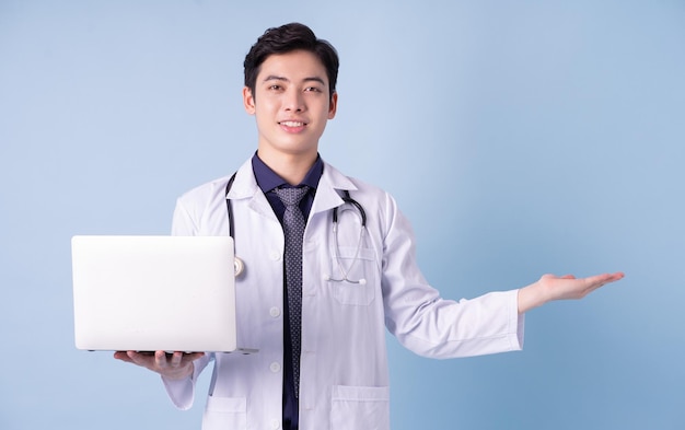 Retrato de um jovem médico asiático sobre fundo azul