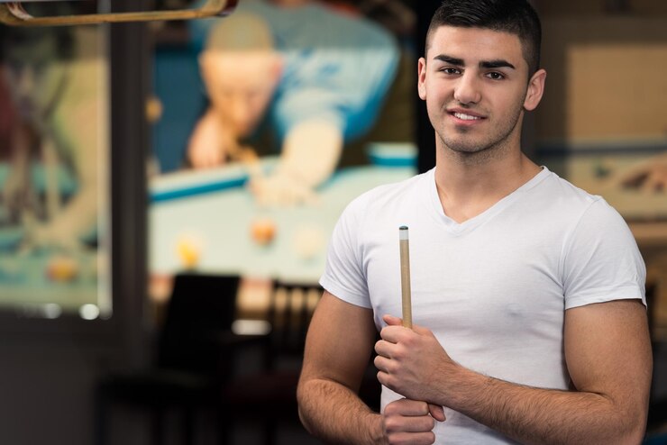 Foto retrato de um jovem modelo masculino jogando bilhar