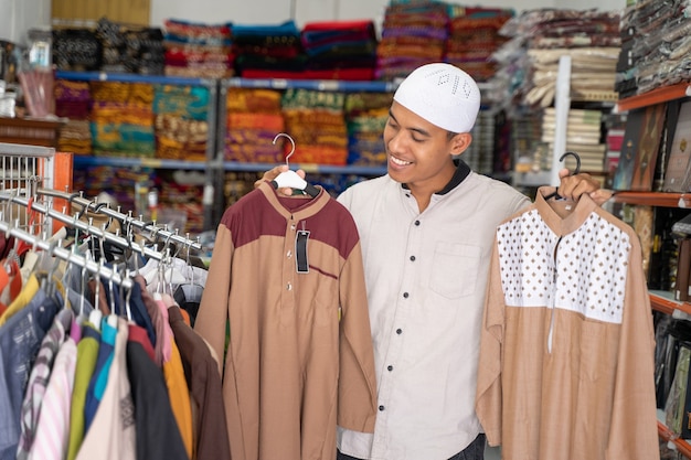 Retrato de um jovem muçulmano asiático comprando roupas na loja