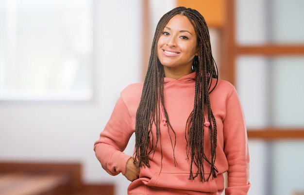 Retrato, de, um, jovem, mulher preta, desgastar, tranças, alegre, e, com, um, grande sorriso