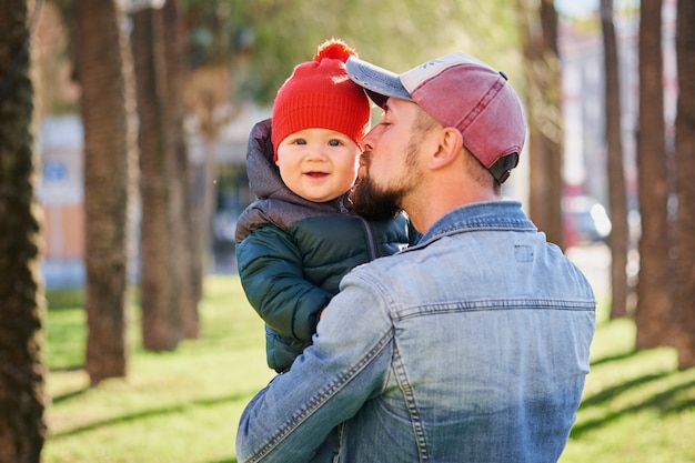 Retrato de um jovem pai feliz andando com seu filho pequeno