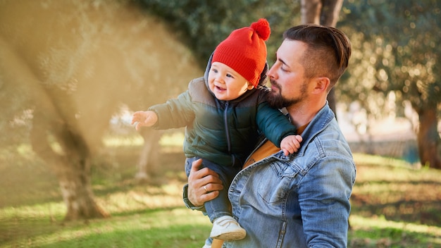 Retrato de um jovem pai feliz andando com seu filho pequeno