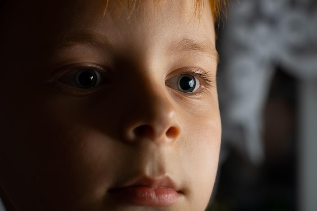 Retrato de um jovem ruivo em um quarto escuro fechado