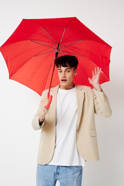 Retrato de um jovem segurando um guarda-chuva nas mãos de posar fundo leve de moda inalterado