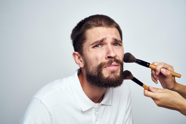 Retrato de um jovem segurando uma guitarra contra um fundo branco