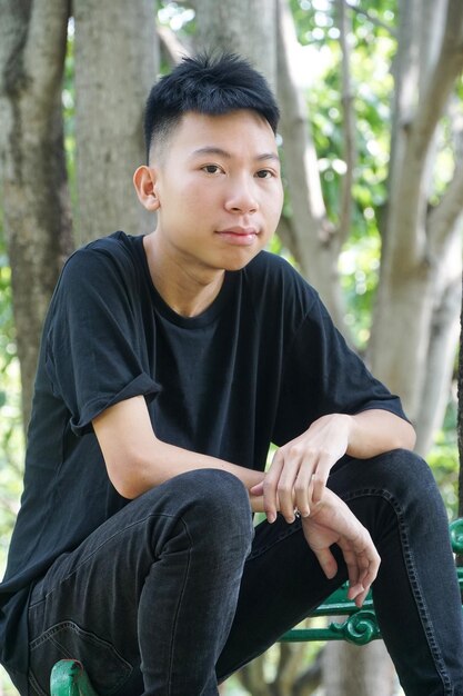 Foto retrato de um jovem sentado ao ar livre