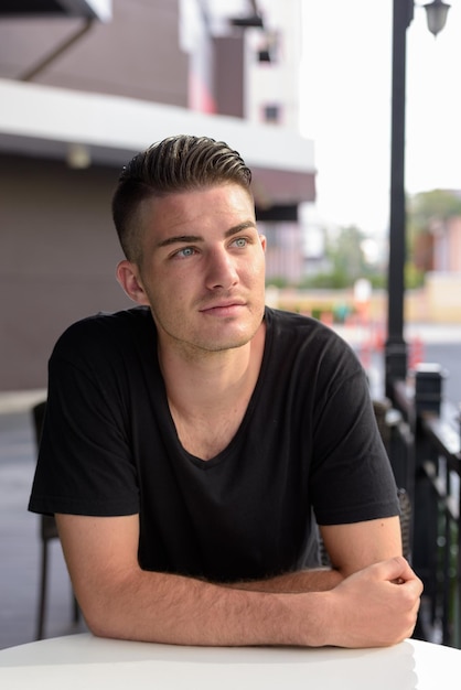 Foto retrato de um jovem sentado em uma mesa