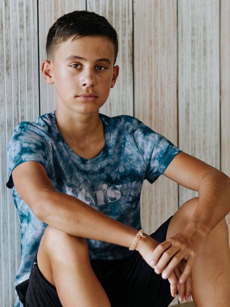 Foto retrato de um jovem sentado no chão de madeira