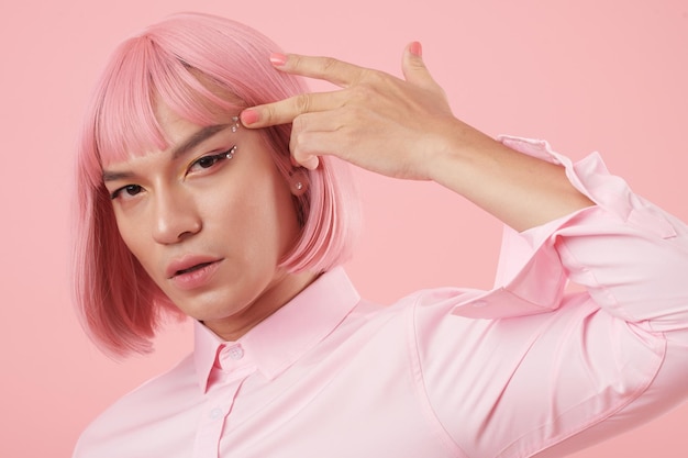 Retrato de um jovem sério usando delineador, strass cintilantes e peruca rosa