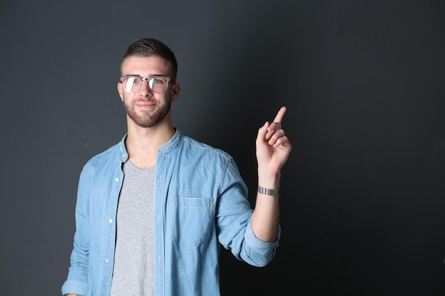 Retrato de um jovem sorridente apontando para cima