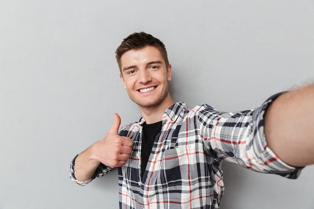 Retrato de um jovem sorridente com camisa xadrez