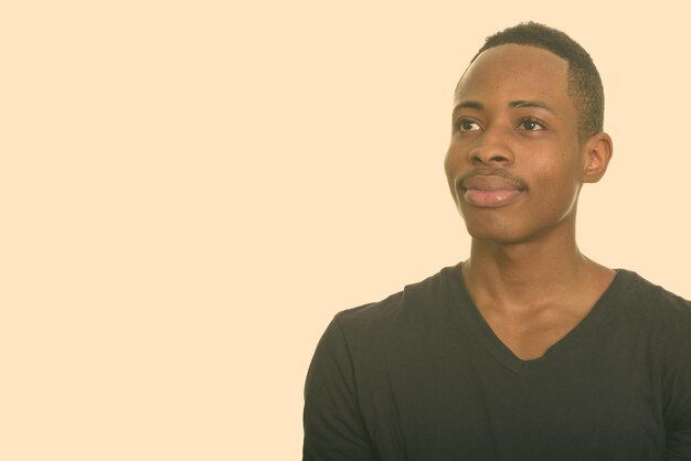 Foto retrato de um jovem sorridente contra um fundo cinzento