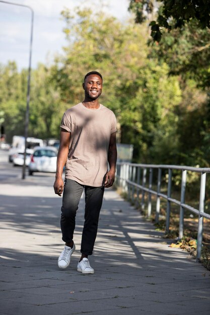 Foto retrato de um jovem sorridente de pé na estrada