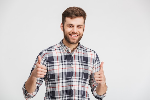 Retrato de um jovem sorridente mostrando os polegares para cima