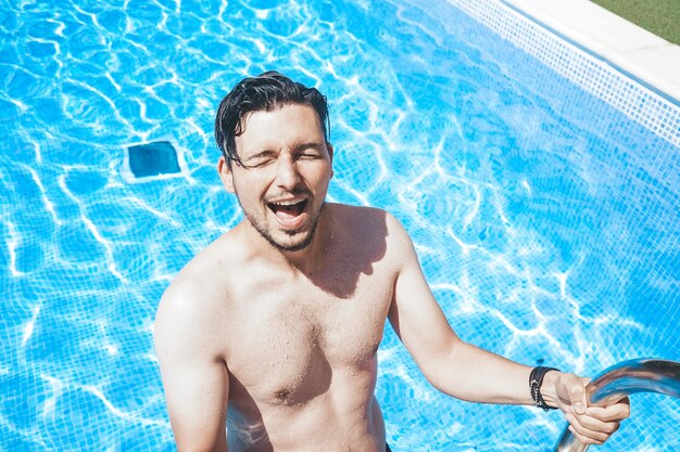 Foto retrato de um jovem sorridente na piscina