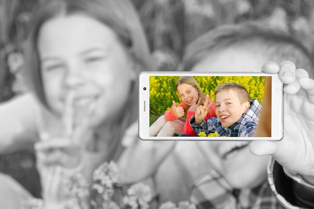 Foto retrato de um jovem sorridente usando um telefone celular