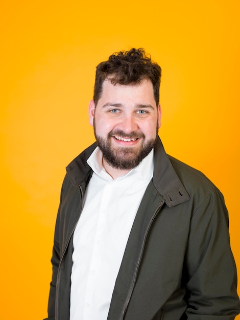 Retrato de um jovem sorrindo enquanto está de pé contra um fundo amarelo