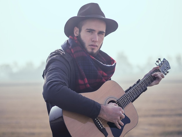 Foto retrato de um jovem tocando guitarra