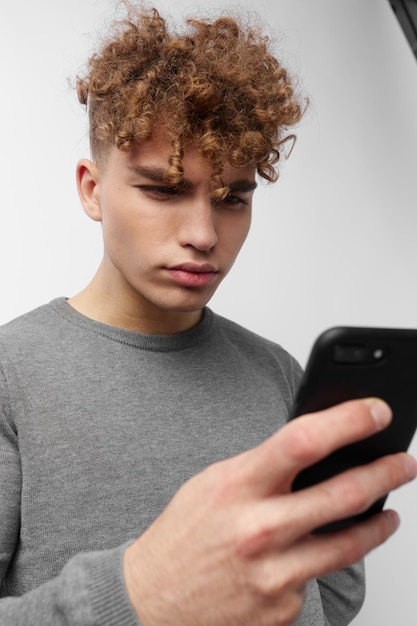 Foto retrato de um jovem usando um telefone celular