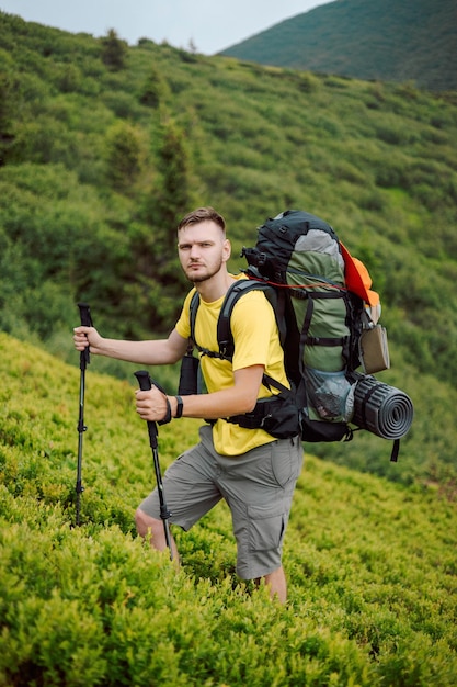 Retrato de um jovem viajante masculino posando para uma foto nas montanhas ao pôr do sol