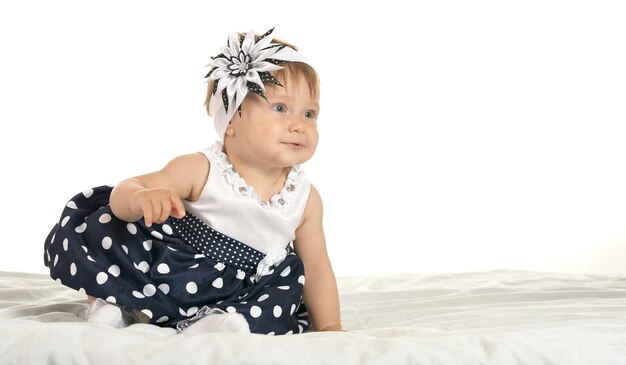 Foto retrato de um lindo bebê em um lindo vestido com uma flor na cabeça