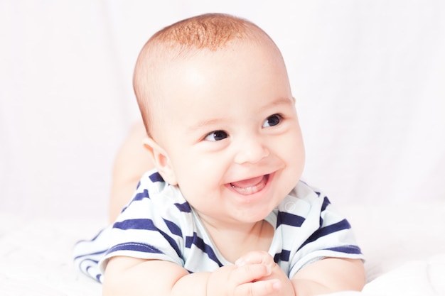 Retrato de um lindo bebê sorridente mostrando o primeiro leite ou dentes temporários