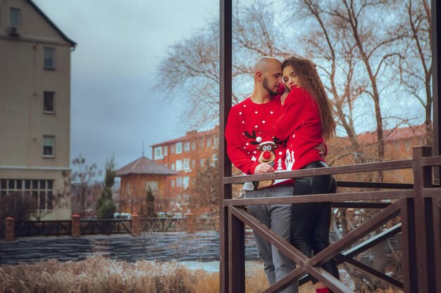 Retrato de um lindo casal abraços na varanda, tempo de inverno. espírito de natal