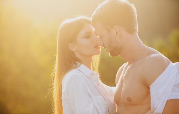 Retrato de um lindo casal apaixonado ao pôr do sol, jovem namorada sensual feliz por um beijo apaixonado dele