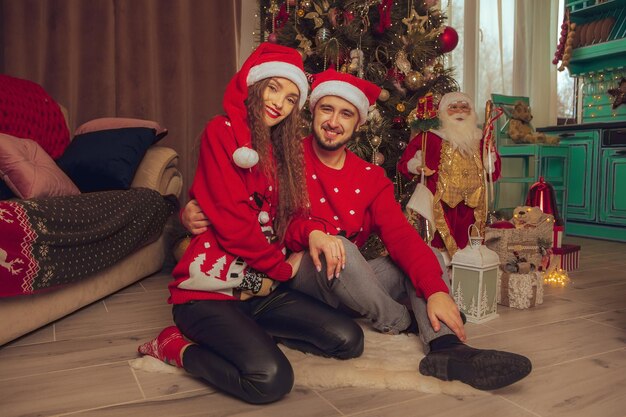 Retrato de um lindo casal apaixonado celebrando o ano novo e o Natal juntos em casa