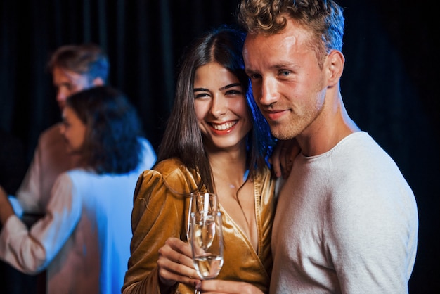 Retrato de um lindo casal ter festa junto com seus amigos.